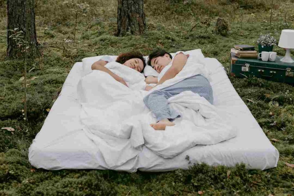 Aman and women sleep on mattresses outside the lawn